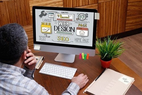 man on computer looking at web design graphic